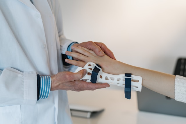 IMage of a doctor putting splint on patient's hand.